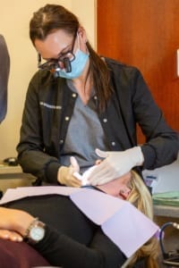 dental hygienist working on patient dental hygienist working on patient